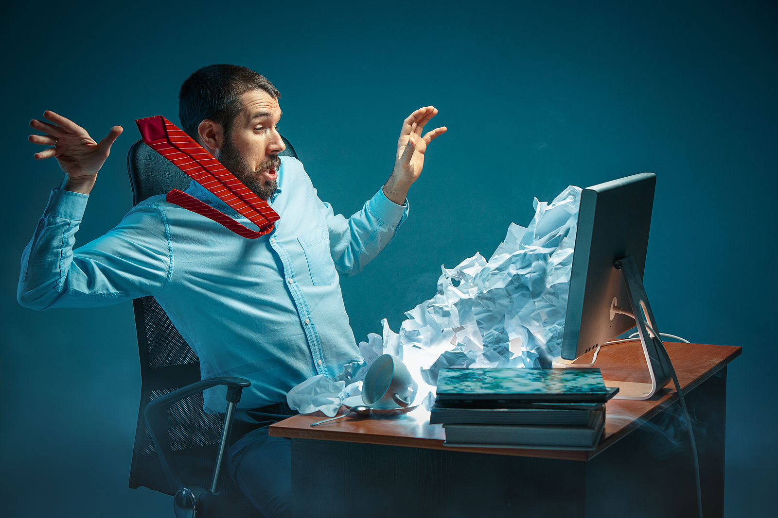 Man in front of laptop can't defend against spam email appearing to blast out at him